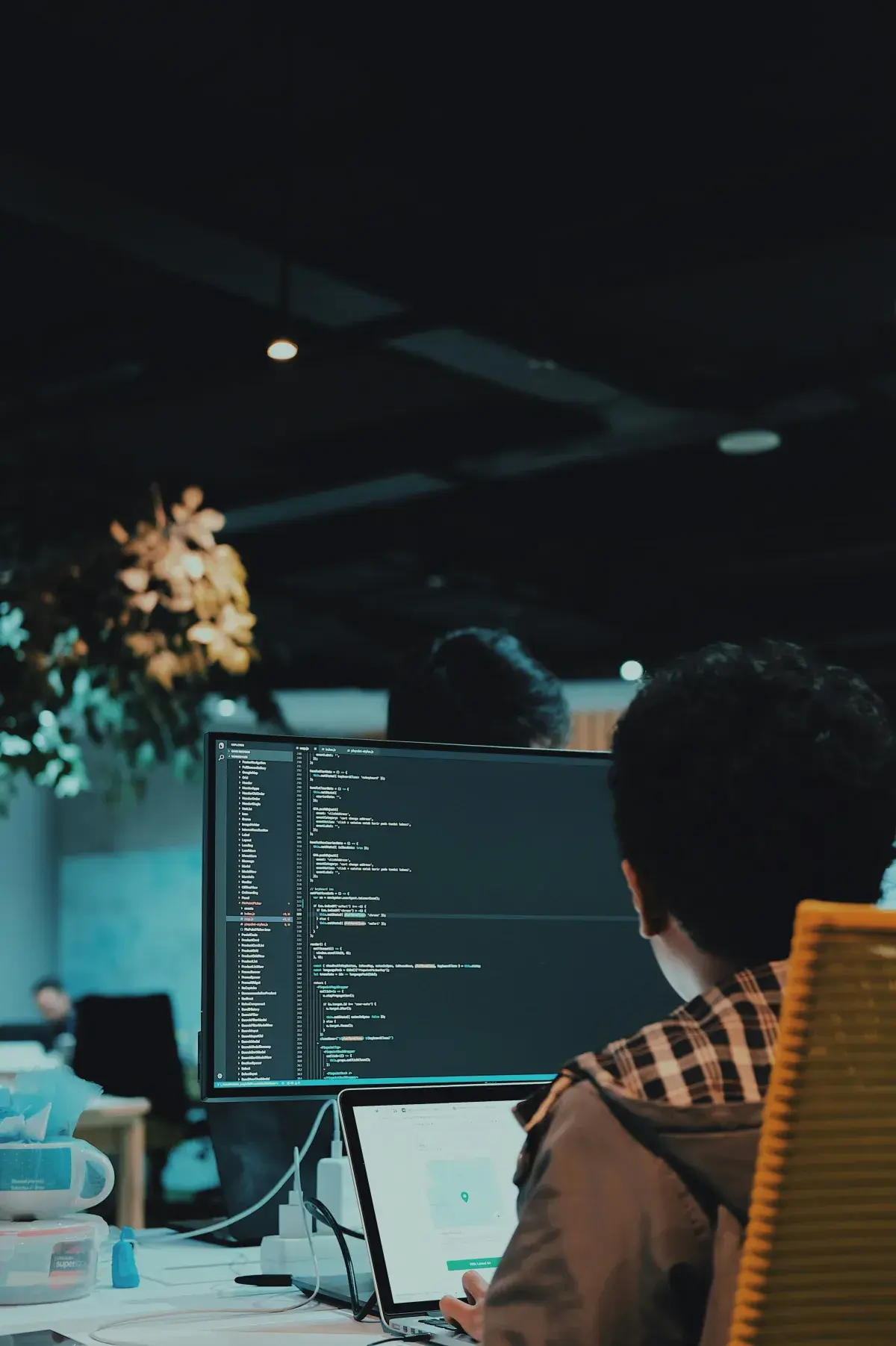 Engineer reviewing code and configuration on a large monitor in a dark office, as in a Microsoft 365 environment review