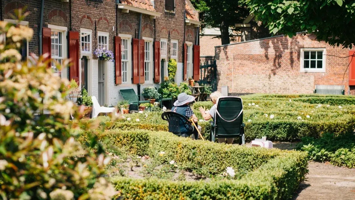 Residents talking in the garden courtyard of a senior living community