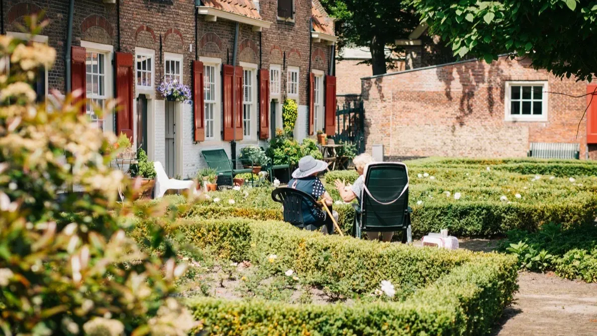 Residents talking in the garden courtyard of a senior living community