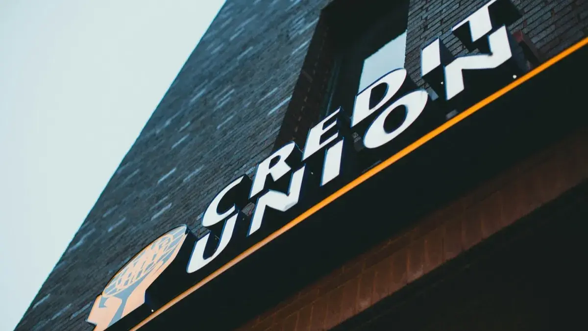 A credit union sign mounted on a dark brick building