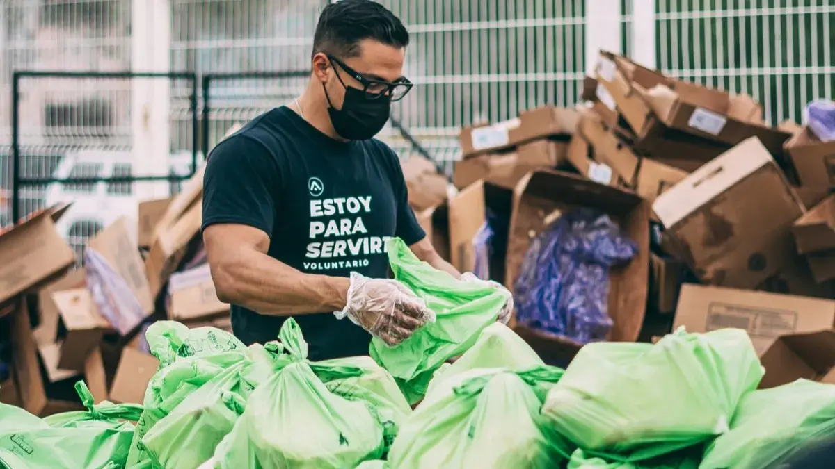 A volunteer sorting donated goods into bags at a nonprofit distribution event