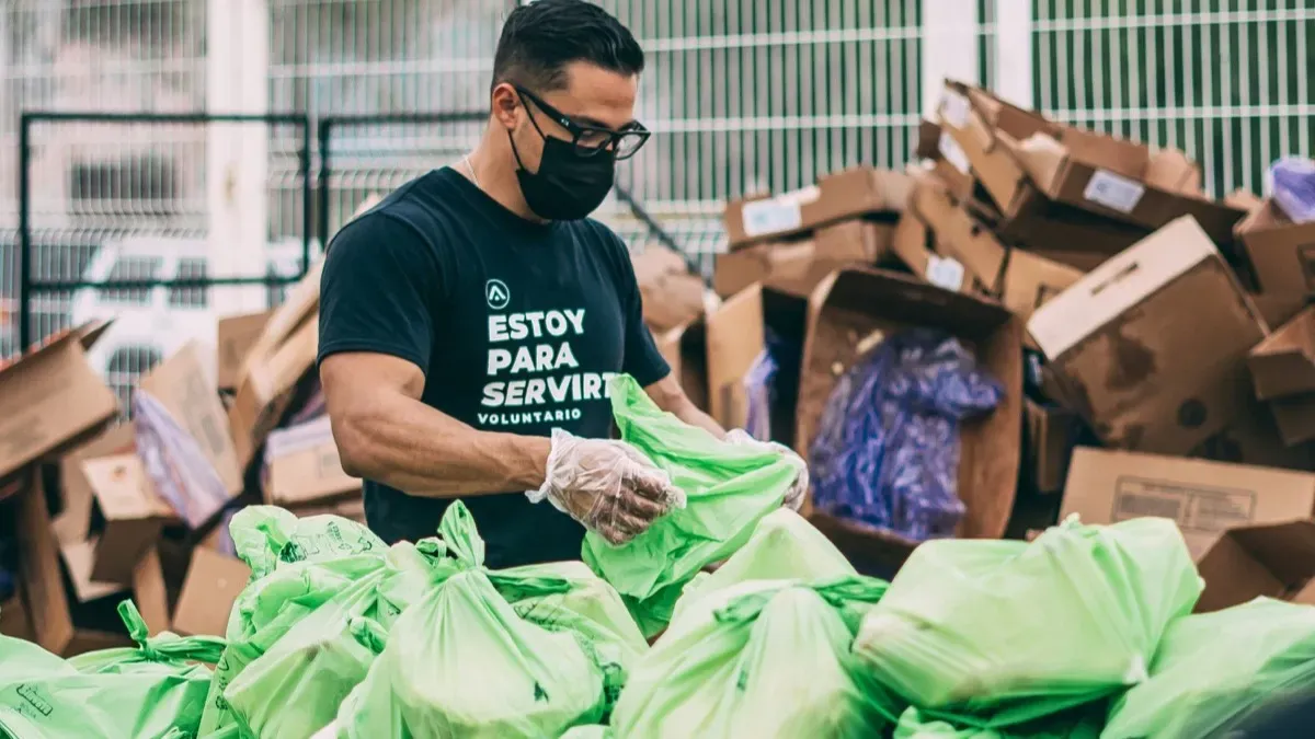 A volunteer sorting donated goods into bags at a nonprofit distribution event